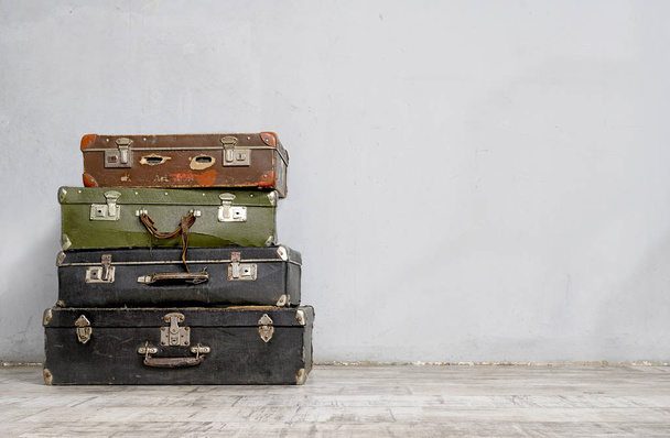Old suitcases stack near the white wall - Photo, Image