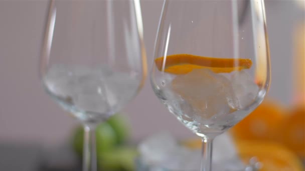 Portakal dilimini buzlu bir bardağa koymak. Kokteyllerin hazırlanması - Video, Çekim