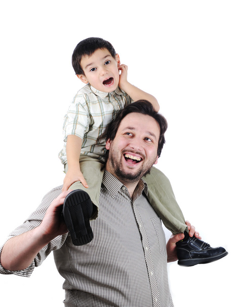 Man giving young boy piggyback ride outdoors smiling - 写真・画像