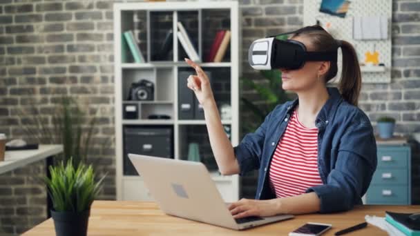 jonge vrouw met behulp van virtual reality bril op het werk bewegende handen tijdens de pauze - Video