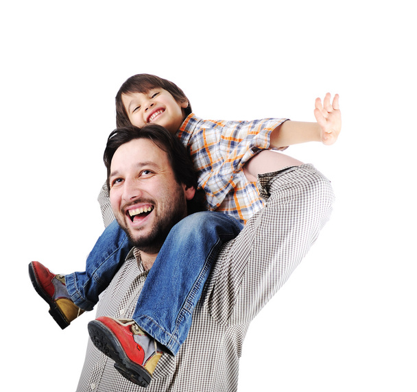 Man giving young boy piggyback ride outdoors smiling - Φωτογραφία, εικόνα