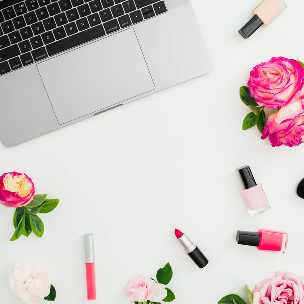 Laptop, rosas flores y cosméticos femeninos aislados sobre fondo blanco. Acostado. Vista superior. Composición del marco con espacio de copia
 - Foto, Imagen