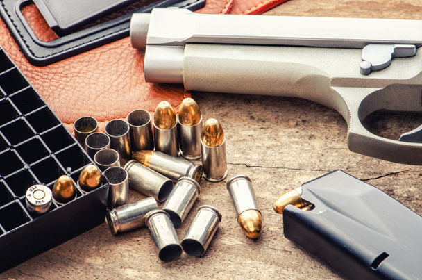9 χιλιοστών όπλο πιστόλι σφαίρες και το περιοδικό σκορπισμένο στο ξύλινο φόντο επάνω όψη - Φωτογραφία, εικόνα