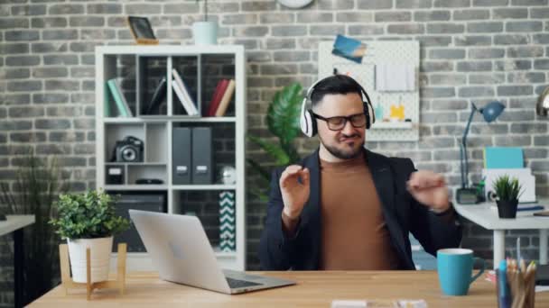 Joyful person office worker listening to music dancing having fun at work - Felvétel, videó