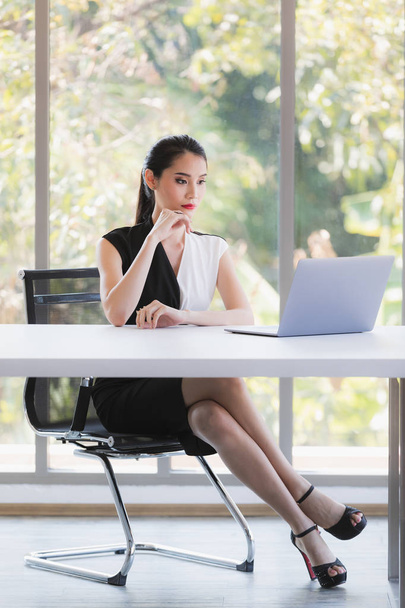 Asian businesswoman looking at laptop in office - Fotoğraf, Görsel
