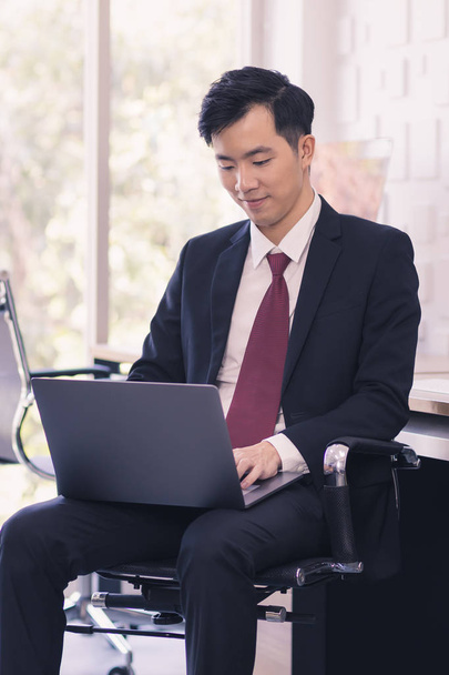 Ázsiai üzletember használja laptop az irodában - Fotó, kép