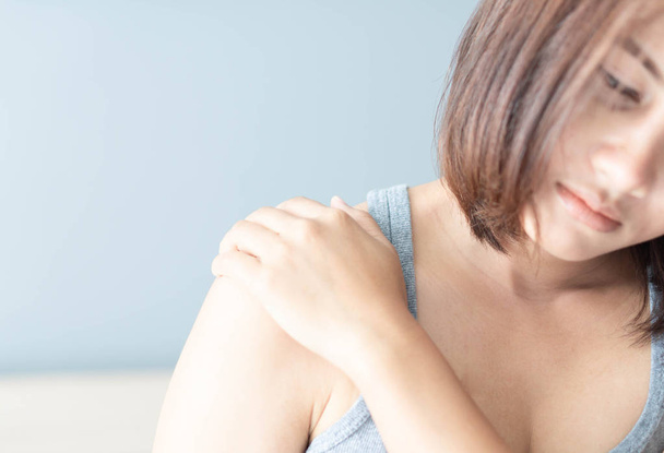 Closeup woman hand holding shoulder with pain on white backgroun - Fotó, kép