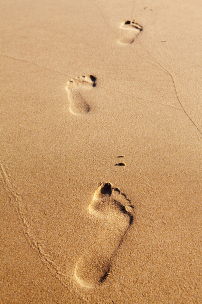 Három emberi lábnyomok a tengerparti homok - Fotó, kép