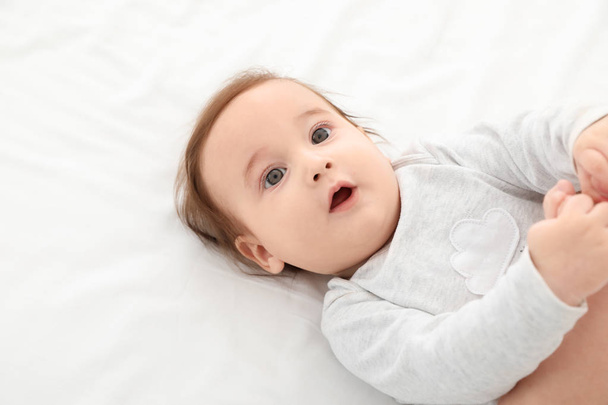 Portrait of adorable baby lying on bed. Space for text - Fotografie, Obrázek
