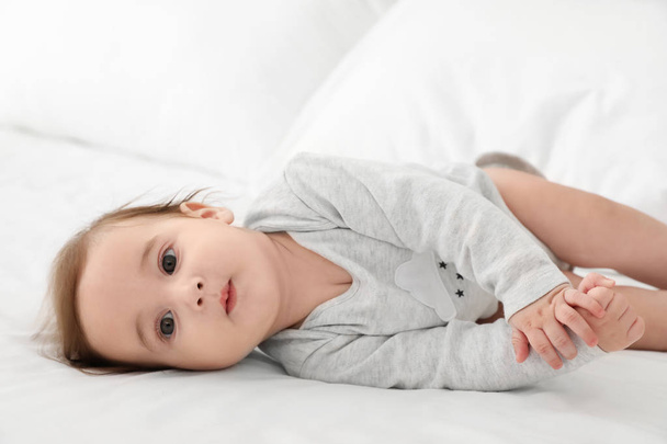 Portrait of adorable baby lying on bed - Foto, Imagem
