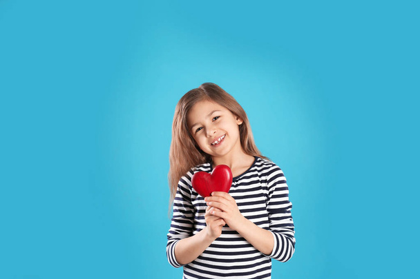 Portrait of girl with decorative heart on color background - Фото, изображение