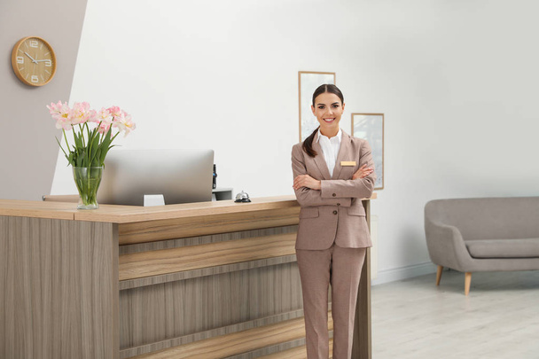 Portrait of receptionist near desk in modern hotel - 写真・画像