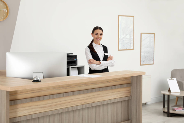 Portrait of receptionist at desk in modern hotel - Фото, зображення