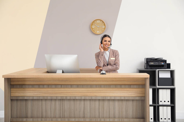 Portrait of receptionist working at desk in modern hotel - Foto, Bild