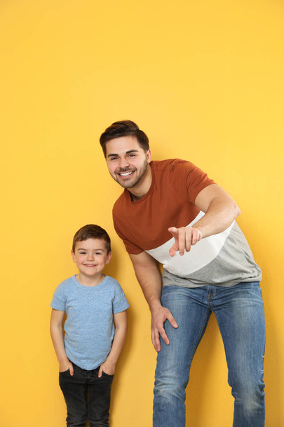 Portrait of dad and his son on color background - Foto, Imagen