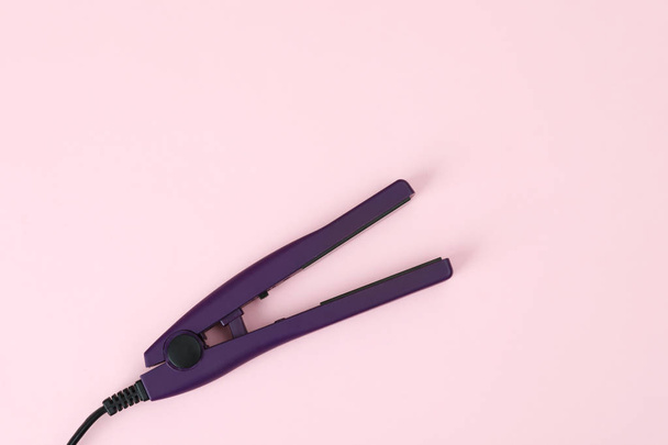 Modern hair iron for straightening on color background, top view - 写真・画像