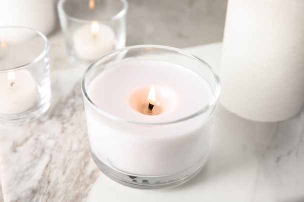 Burning aromatic candle in holder on table - Foto, Bild