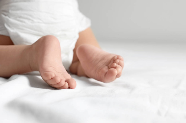 Cute little baby crawling on white bed sheet, closeup. Space for text - Foto, immagini