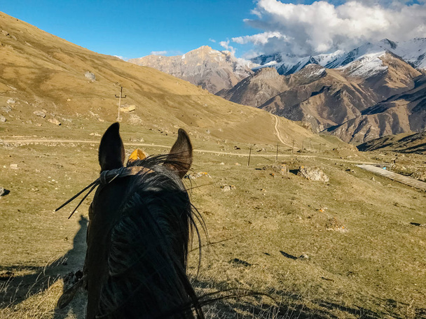 montando um cavalo vista em primeira pessoa e uma vista das montanhas
 - Foto, Imagem