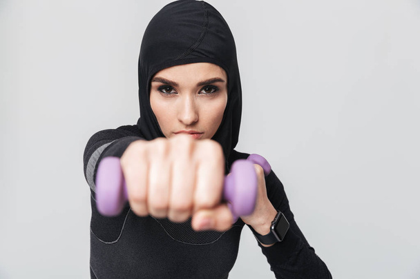 Muslim fighter boxer posing isolated over white wall background make exercises with dumbbells. - Fotoğraf, Görsel