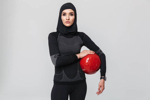 Woman fitness muslim posing isolated over white wall background make exercises with ball. - Foto, Imagem