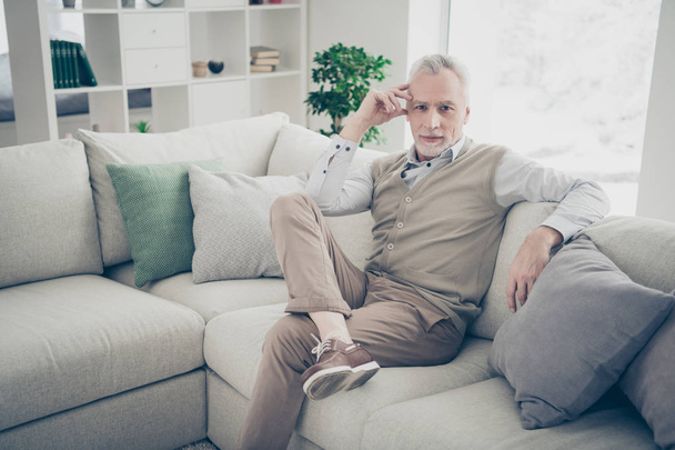 Close up photo amazing he him his aged man inspiration calm peaceful kindhearted easy-going serious look wear white shirt waistcoat pants sit cozy comfort divan bright flat house living room indoors - Foto, immagini