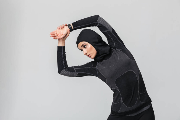 Young woman fitness muslim make stretching exercises isolated over white wall background. - Foto, Bild