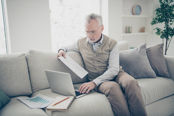 Close up side profile photo amazing he him his aged man hand arm notebook search analyzer check information charts stats wear white shirt waistcoat pants sit cozy divan flat house living room indoors - Fotografie, Obrázek