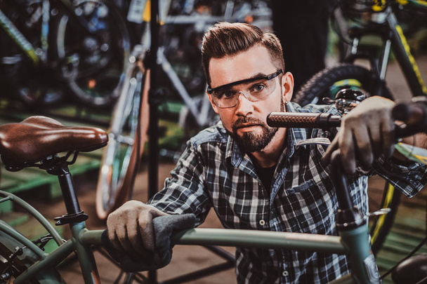 Усердный человек проверяет велосипеды цепи для клиентов
. - Фото, изображение