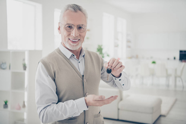 Close up photo friendly amazing he him his aged man arm hand new keychain entrance specialist give buy buyer seller proposition offer wear shirt waistcoat comfy bright flat house living room indoors - Photo, Image