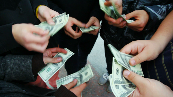 Manos de cinco jóvenes cuentan billetes de cien dólares
 - Imágenes, Vídeo