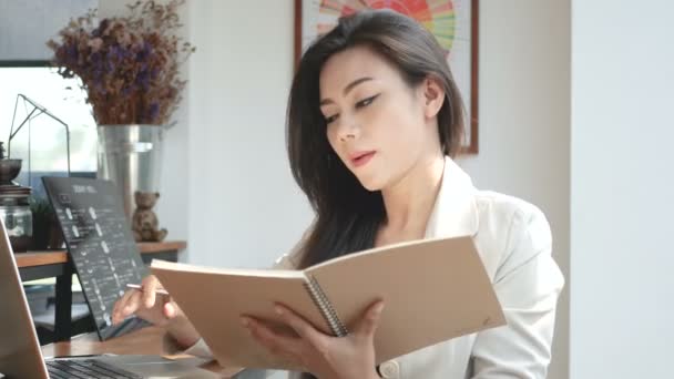 4K footage, busy business woman working with laptop computer and note book in coffee shop cafe in the city in the morning , business people lifestyle. Asian model in her 30s - Filmagem, Vídeo