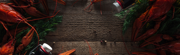 plano panorámico de langostas rojas, eneldo y botellas de vidrio en la superficie de madera
 - Foto, Imagen