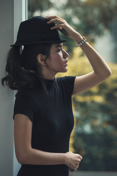 portrait of a Beautiful asia woman in dark dress and black hat s - Photo, Image