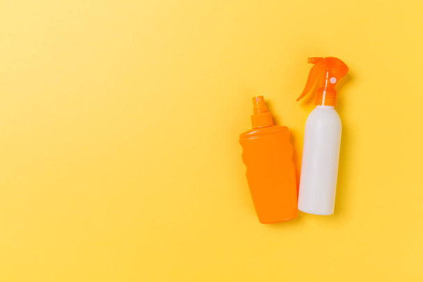 flat lay concept of summer travel vacation. Sunscreen bottle mock up on yellow background top view with copy space - Zdjęcie, obraz