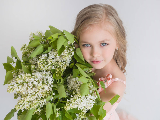 Beautiful girl with a lilac in the hands of - Фото, изображение