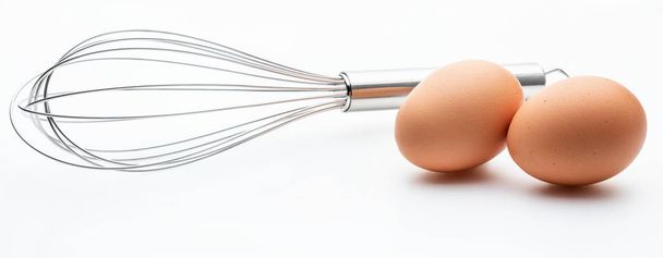 2 taze yumurta (pişirme nesneleri koleksiyonu) ile el ile gıda karıştırma için metalik mutfak çubukları. Beyaz arka planda yalıtılmış. - Fotoğraf, Görsel