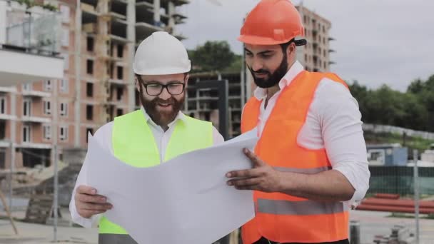 Building a residential complex or business center. Team of engineers men analyze plans construction builders job activity. Experts are satisfied with the construction plan. - Πλάνα, βίντεο