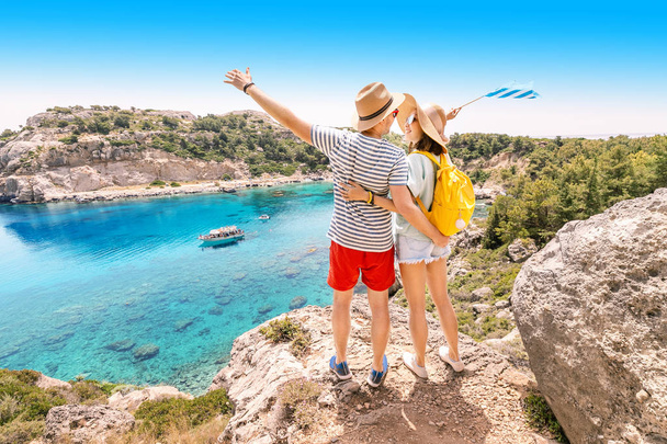 Szczęśliwa para zakochanych o podróży wakacje i stoi na szczycie wzgórza z widokiem na atrakcyjne niebieskie zatoki morskiej. - Zdjęcie, obraz