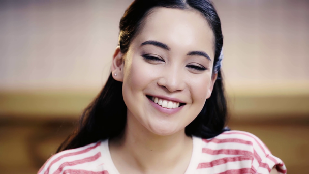 mooi, brunette, Aziatische vrouw kijken naar camera en glimlachend in café  - Video