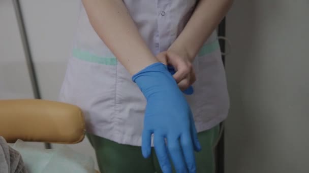 Professional cosmetologist wears blue rubber gloves for the procedure. - Footage, Video