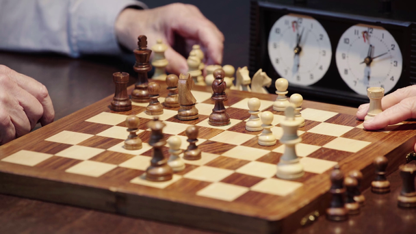 частковий вид на двох старших чоловіків, які жестикулюють під час гри в шахи за столом
 - Кадри, відео