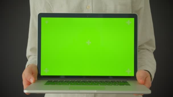 Closeup shoot of male hands holding a laptop with green screen indoors with background isolated on gray - Video