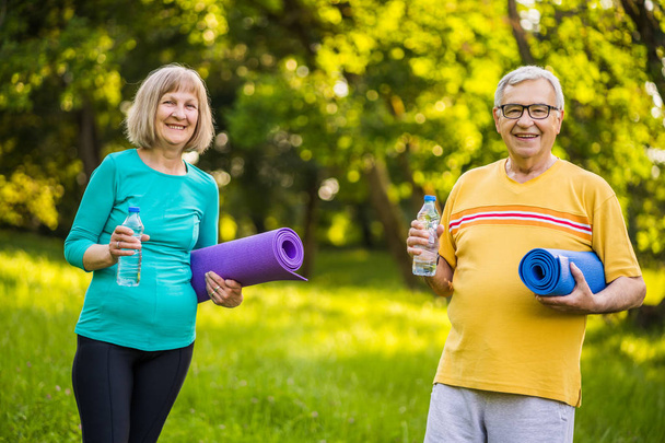Ευτυχισμένο ζευγάρι ηλικιωμένων είναι έτοιμο για άσκηση στο πάρκο. - Φωτογραφία, εικόνα