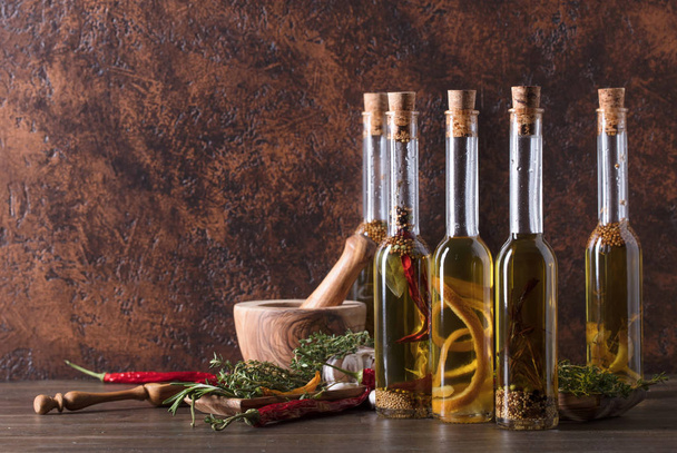 Bottles of olive oil with different spices and herbs. - Photo, image