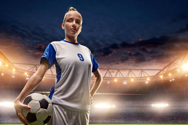 Θηλυκός ποδοσφαιριστής με μπάλα σε ένα επαγγελματικό στάδιο ποδοσφαίρου - Φωτογραφία, εικόνα