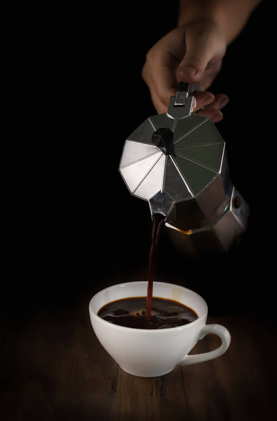 hand pouring coffee from coffee pot in cup - Photo, image