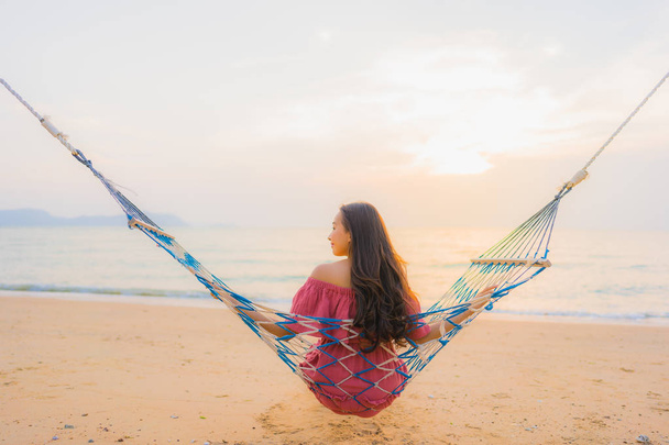 Retrato hermosa joven asiática mujer sentado en la hamaca con
 - Foto, imagen
