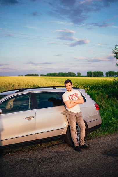 handsome young man near car on nature - Фото, зображення
