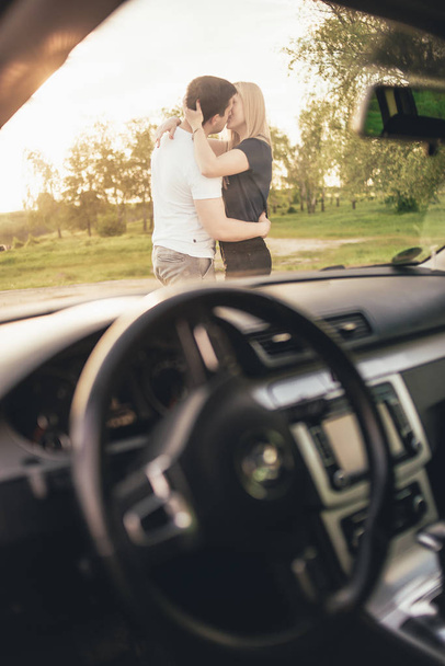 beautiful young couple kissing near car during trip - Foto, imagen